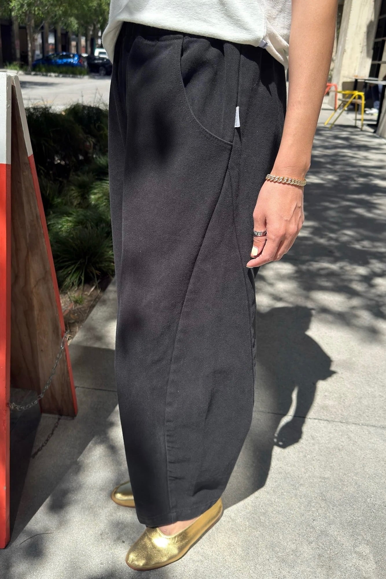 Side view of Le Bon Shoppe Arc Pants in black canvas highlighting the curved seam, roomy pocket and sculptural silhouette.