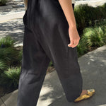 Rear three quarter view of Le Bon Shoppe Arc Pants in black canvas showing the rounded leg shape and cropped hem.