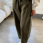 Front view of Le Bon Shoppe olive Arc Pants styled with a cream sweater and ivory clogs, showing the oversized pockets and cropped length.