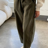 Front view of Le Bon Shoppe olive Arc Pants styled with a cream sweater and ivory clogs, showing the oversized pockets and cropped length.