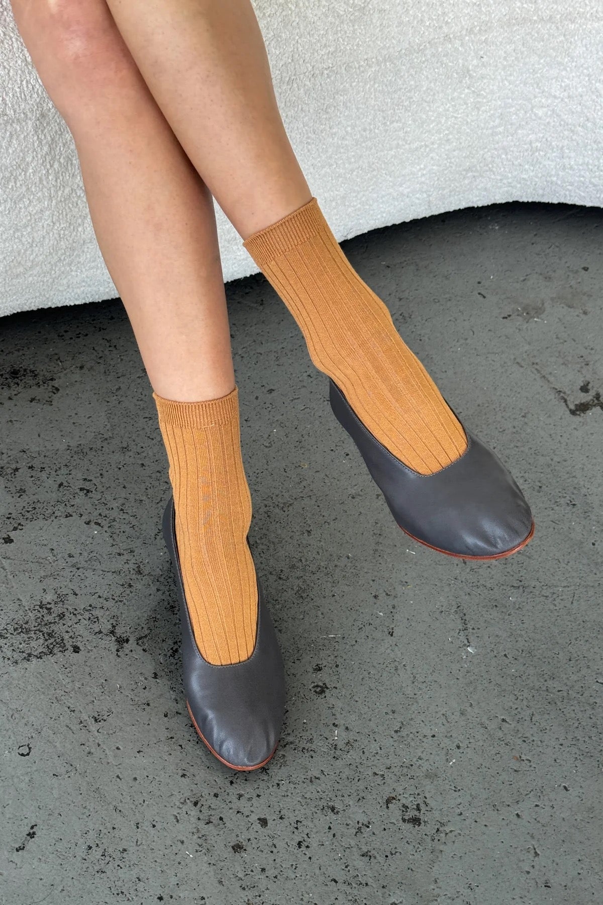 Le Bon Shoppe Peanut Butter Her Socks styled with charcoal leather flats, showing warm caramel color and ribbed texture