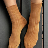 Peanut Butter ribbed cotton socks worn without shoes, showing the fine knit texture, heel and comfortable cuff