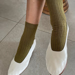 Le Bon Shoppe Her Socks in Pesto worn with white leather ballet flats, showing ribbed texture and relaxed fit