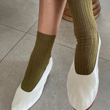 Le Bon Shoppe Her Socks in Pesto worn with white leather ballet flats, showing ribbed texture and relaxed fit