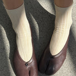 Porcelain cotton blend ribbed socks shown on feet with brown leather flats at YUCCA Denver