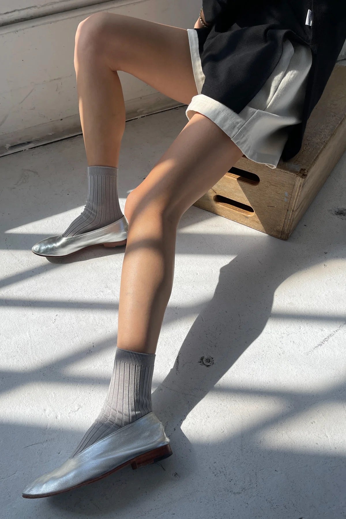 Stone ribbed cotton socks styled with metallic silver ballet flats and relaxed black and white shorts.