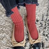 Terracotta ribbed cotton socks styled with frayed dark denim and two tone ballet flats