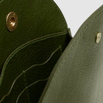 Open LINDQUIST Eggi bag in Olive showing leather card pockets, divided interior compartments, and brass snap