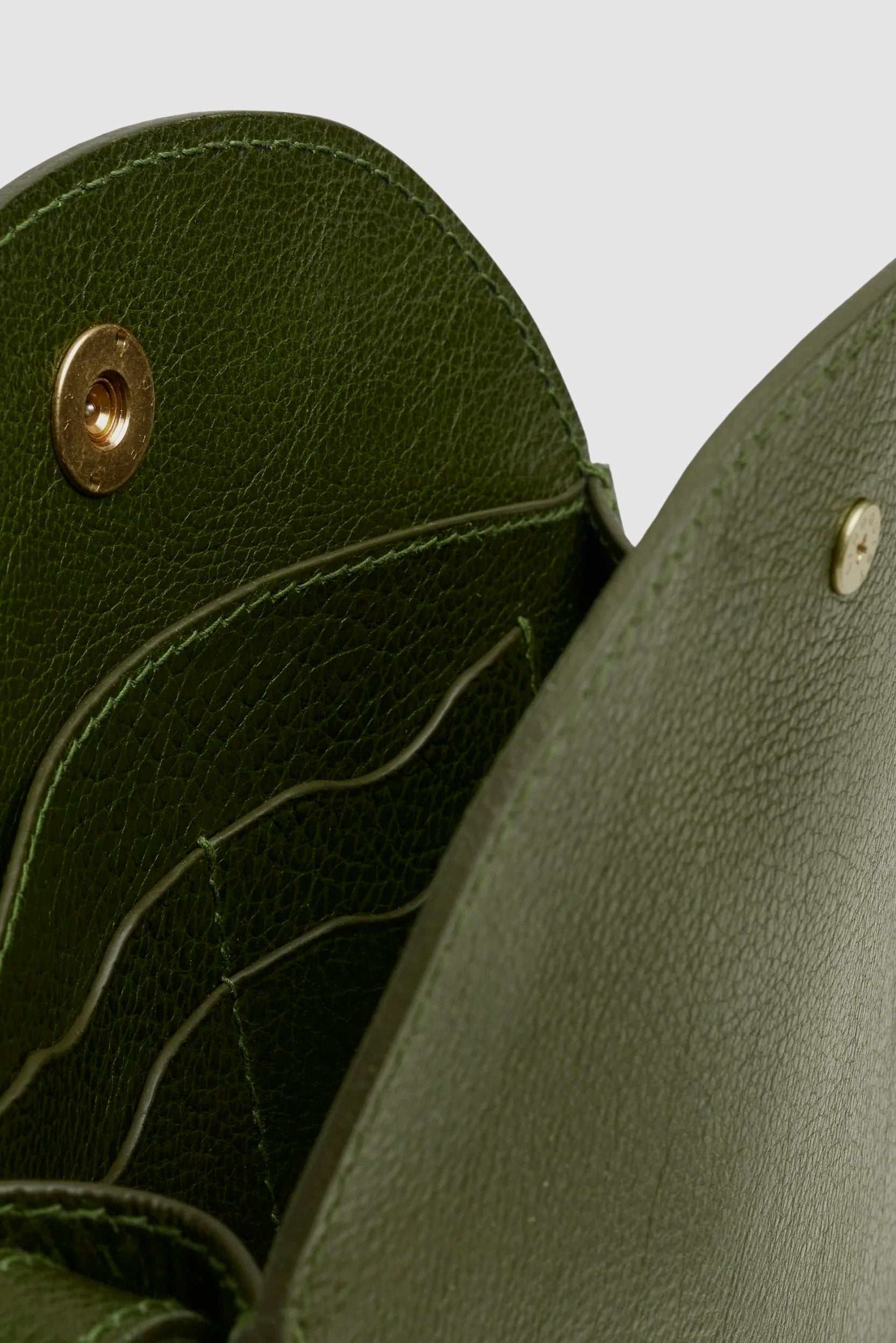 Open LINDQUIST Eggi bag in Olive showing leather card pockets, divided interior compartments, and brass snap