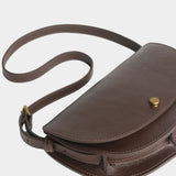 LINDQUIST Mezzo bag in Chaga laid flat with its leather strap curled beside the crescent body