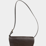 Front view of the LINDQUIST Mezzo bag in Chaga with a curved flap, brass closure, and leather shoulder strap