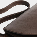 Detail of the Chaga Mezzo bag’s curved leather flap, side gusset, and adjustable strap