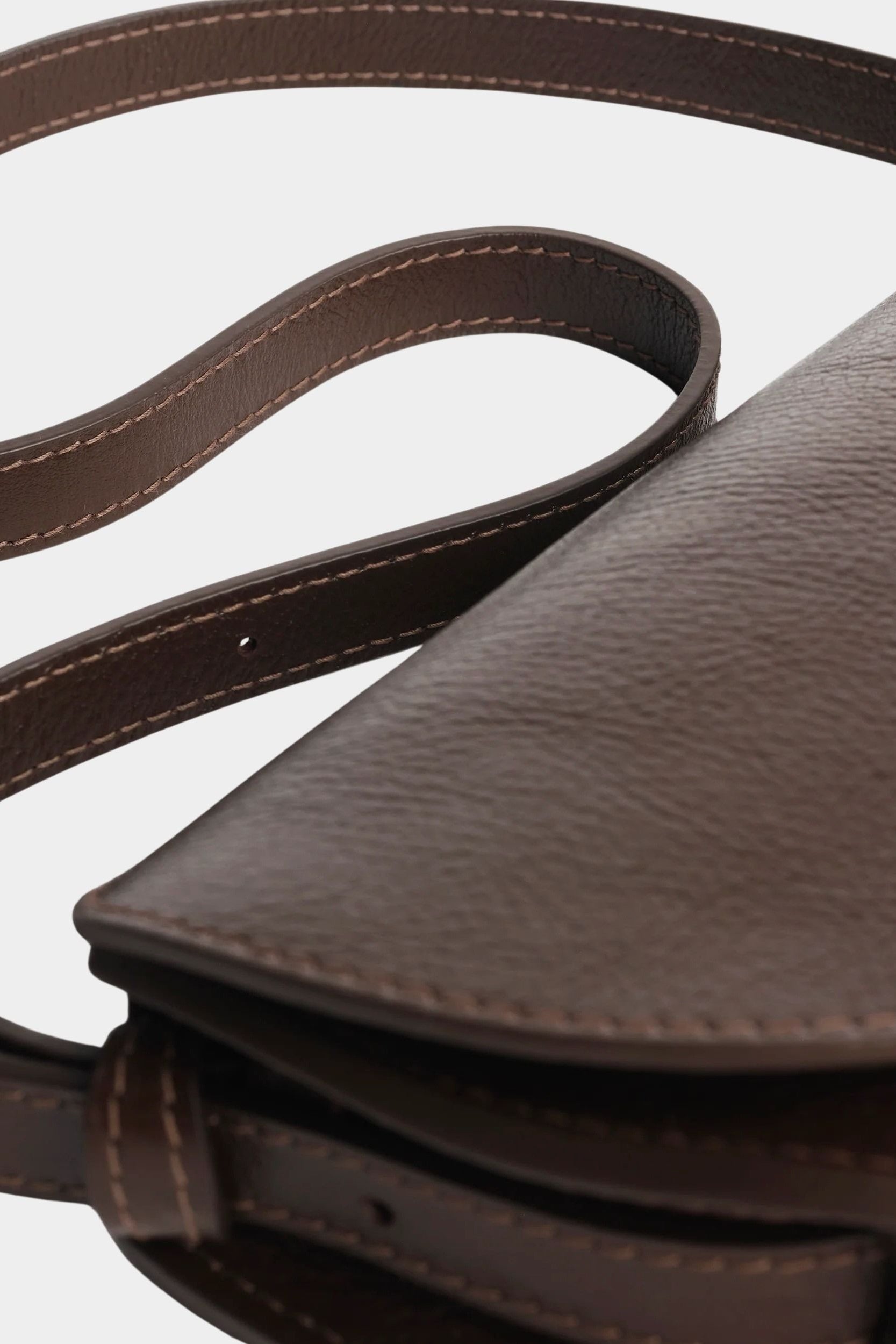 Detail of the Chaga Mezzo bag’s curved leather flap, side gusset, and adjustable strap