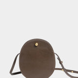 Front view of the Chaga Mini Eggi bag with its adjustable leather strap arranged around the base