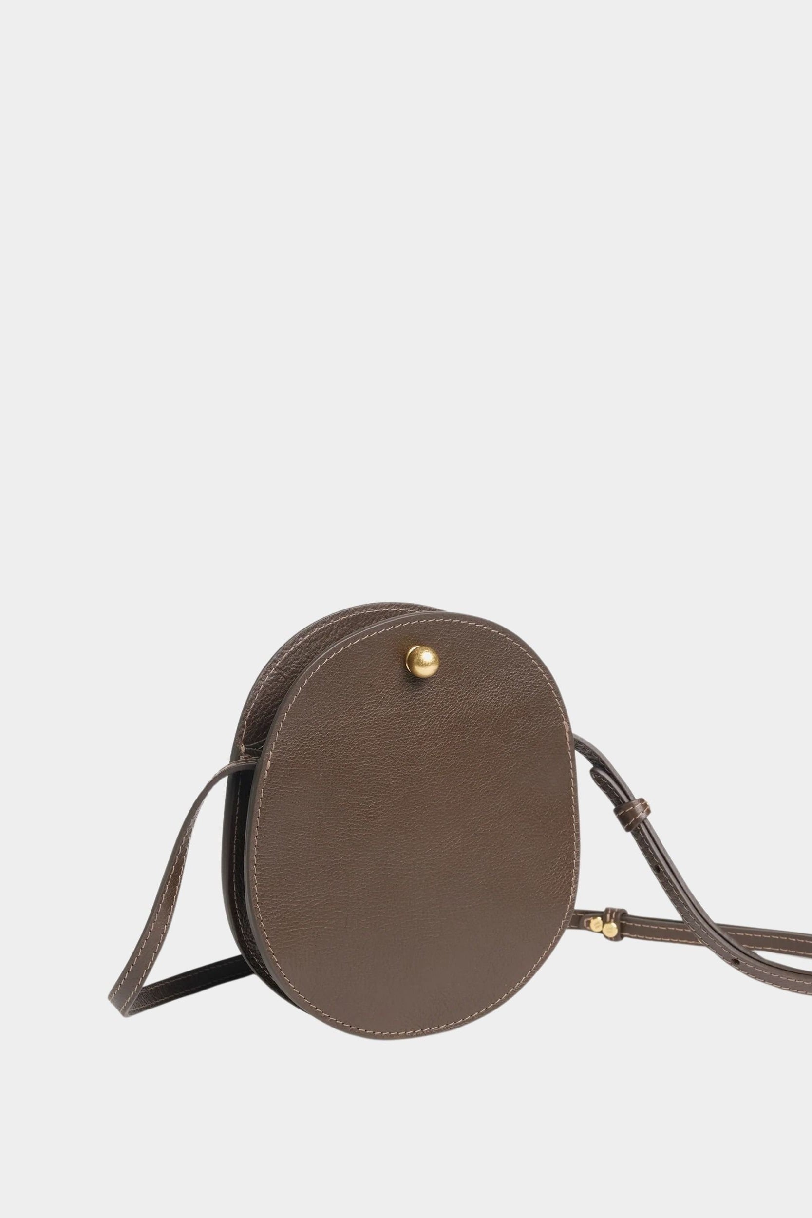 Angled view of the LINDQUIST Mini Eggi bag in Chaga showing its compact profile and brass closure