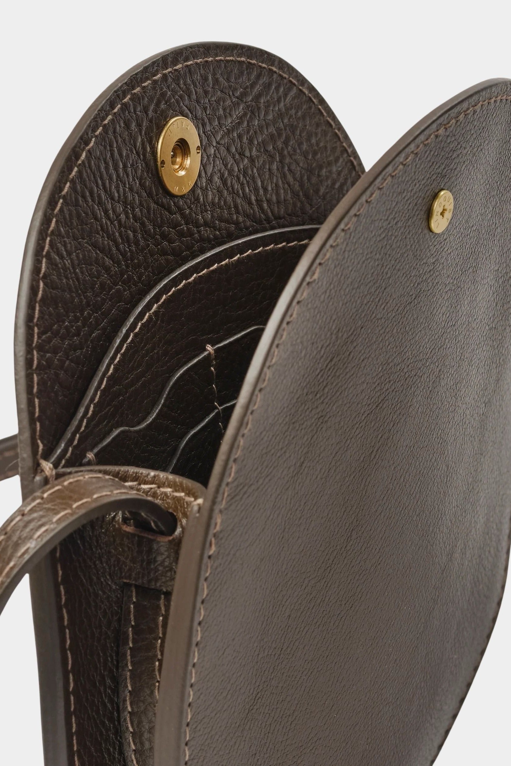 Open LINDQUIST Mini Eggi bag in Chaga showing divided leather compartments, card pockets, and brass snap