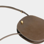 LINDQUIST Mini Eggi bag in Chaga laid flat, showing its oval shape, side gusset, and slim leather strap