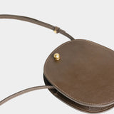 LINDQUIST Mini Eggi bag in Chaga laid flat, showing its oval shape, side gusset, and slim leather strap