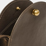 Close view of the Mini Eggi bag’s spherical brass closure and pebbled Chaga leather