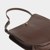 Chaga Savoie bag laid flat, showing its curved leather body, divided interior, and shoulder strap
