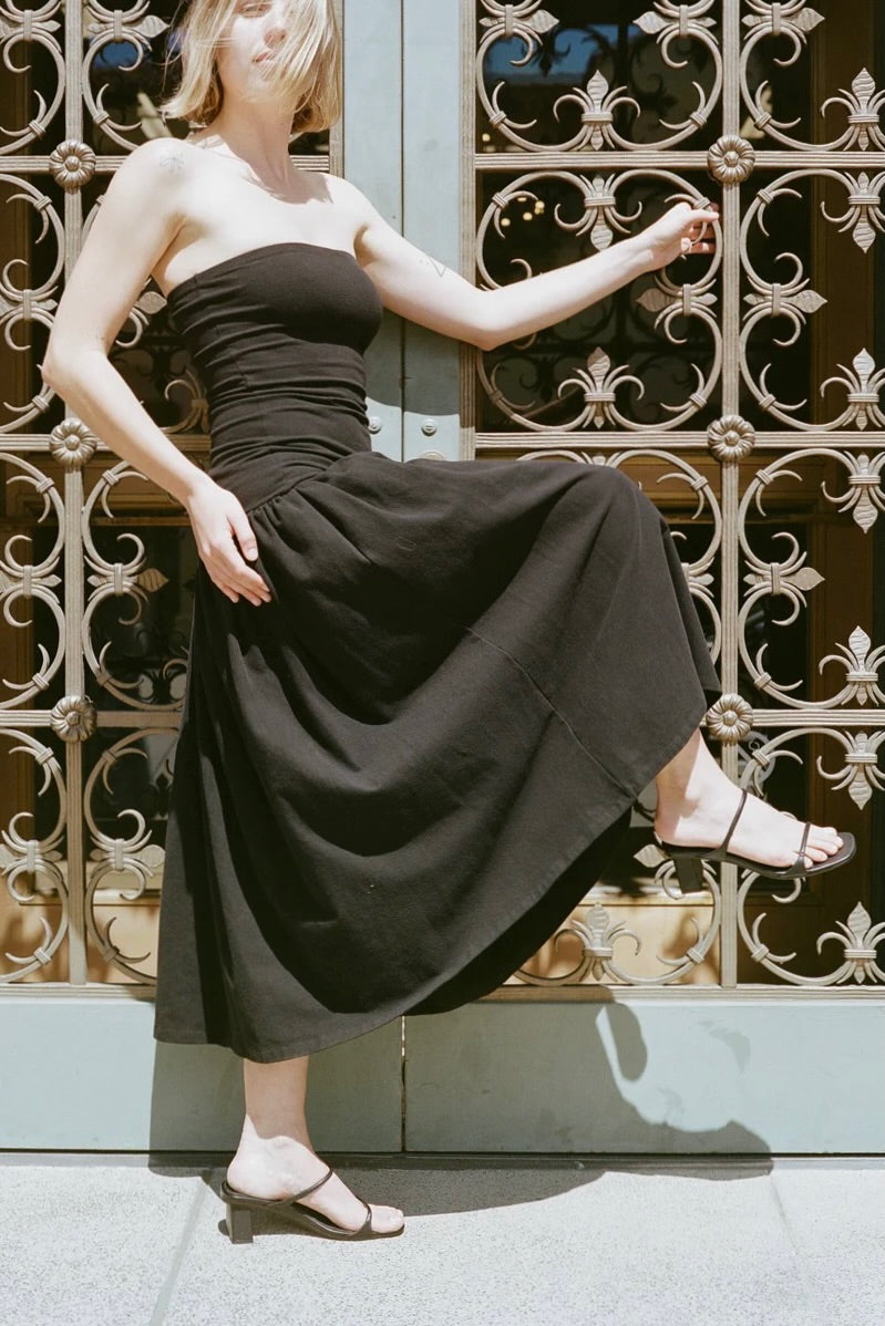 LOQ Gael black leather heeled sandal worn with black strapless midi dress movement shot