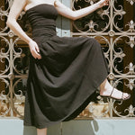 LOQ Gael black leather heeled sandal worn with black strapless midi dress movement shot