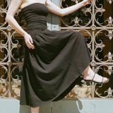 LOQ Gael black leather heeled sandal worn with black strapless midi dress movement shot