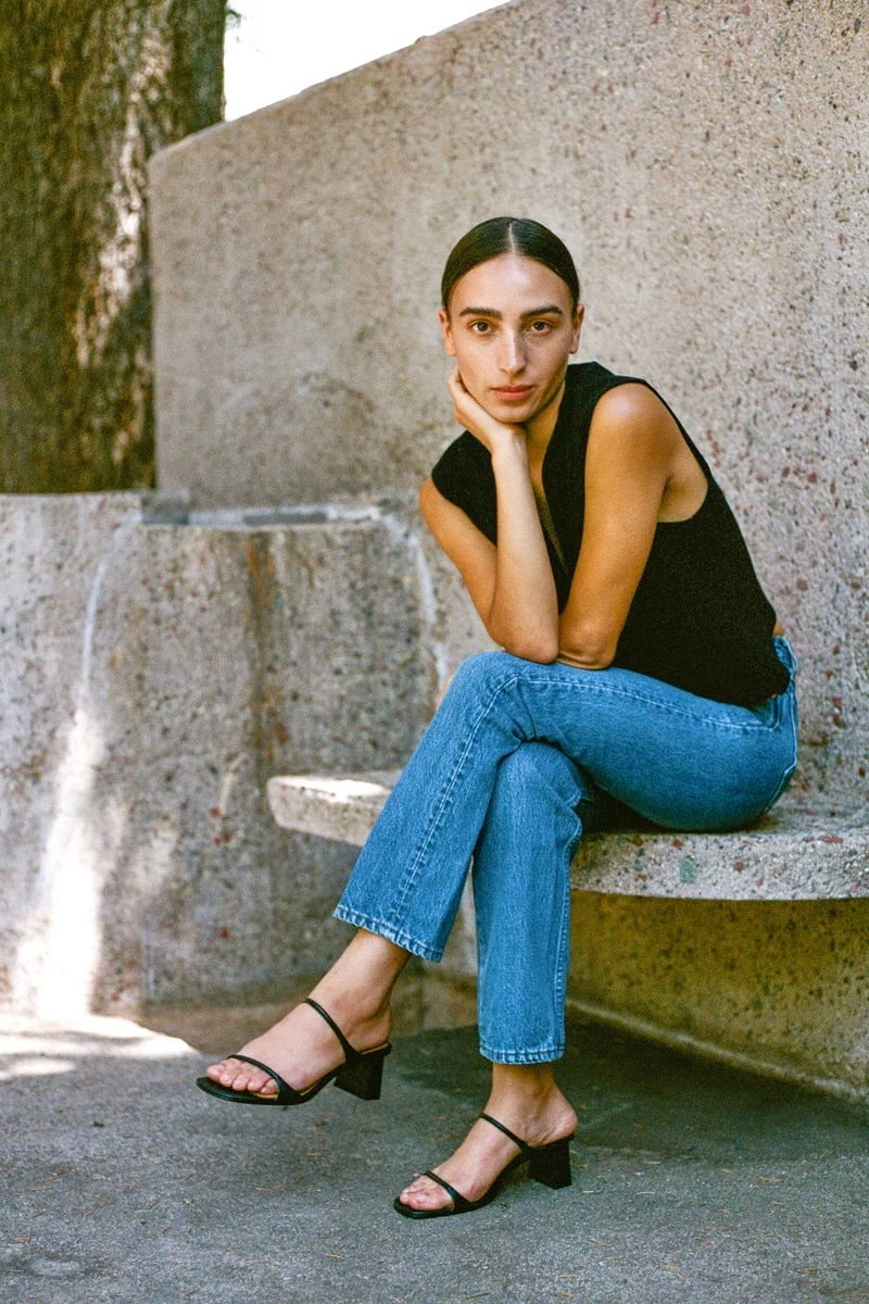 LOQ Gael black leather heeled sandal worn with straight leg jeans outdoor seated