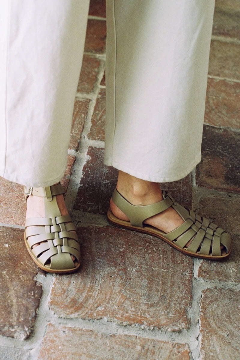 LOQ Rio sandal in taupe worn with cream pants close up showing woven leather fisherman sandal and flat sole