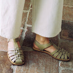 LOQ Rio sandal in taupe worn with cream pants close up showing woven leather fisherman sandal and flat sole