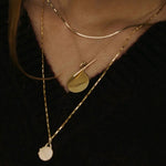 Model wearing 10K gold herringbone chain necklace layered with pendant.