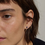 Model wearing 14K gold pear sapphire and diamond hoop earrings.
