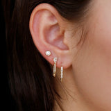 Model wearing 14K gold diamond and sapphire drop hoop earrings.