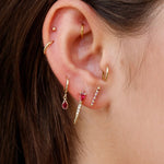 Loren Stewart Mini Ruby Diamond Safety Pin Earring worn in a layered ruby and gold ear stack