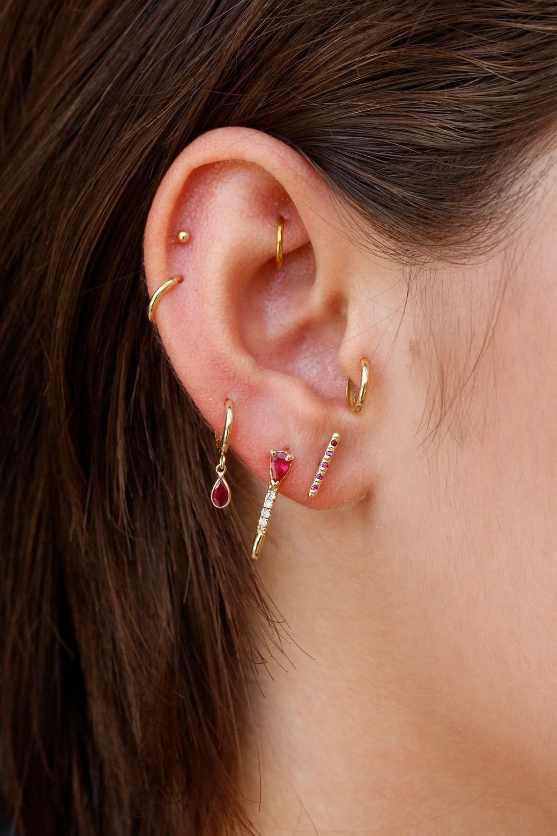 Loren Stewart Mini Ruby Diamond Safety Pin Earring worn in a layered ruby and gold ear stack