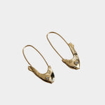 Mirrored Pisces fish earrings in 14k yellow gold displayed on gray fabric