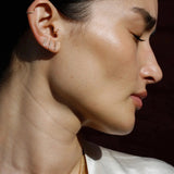 Model wearing 14K gold vertical bar stud earrings.
