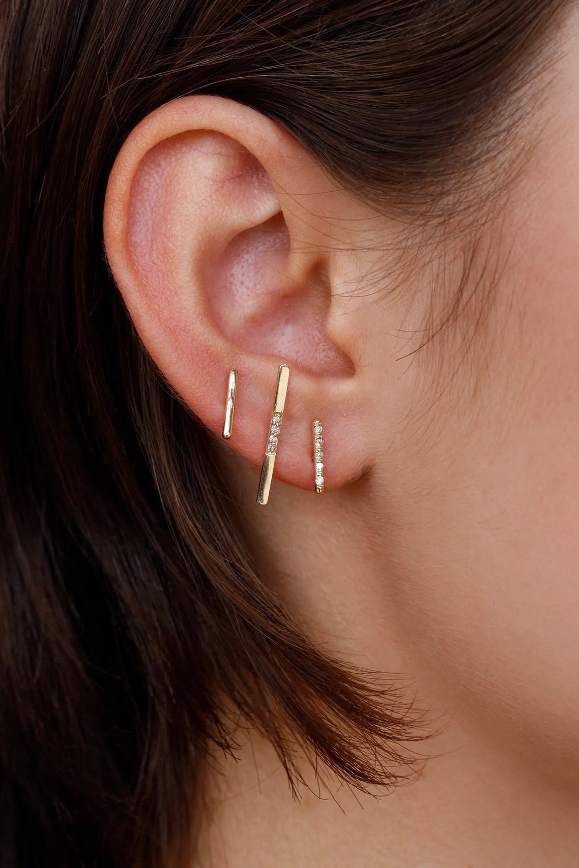 Model wearing 14K gold minimalist vertical bar earrings.