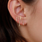 Model wearing 14K gold minimalist vertical bar earrings.