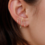 Model wearing 14K gold minimalist vertical bar earrings.