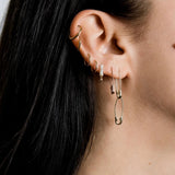 Model wearing 14K gold elongated safety pin earrings.