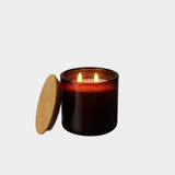 Los Poblanos Vela de la Alhucema Lavender Candle burning in amber glass vessel with wooden lid, lifestyle product image