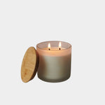 Los Poblanos Vela de la Hacienda Spa Candle with frosted glass vessel, bamboo lid, and double wick candle burning