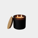 Los Poblanos Vela de la Tierra Candle with matte black vessel, bamboo lid, and double wick candle burning at YUCCA Denver boutique in Denver, Colorado