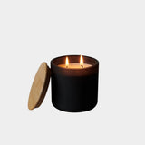 Los Poblanos Vela de la Tierra Candle with matte black vessel, bamboo lid, and double wick candle burning at YUCCA Denver boutique in Denver, Colorado
