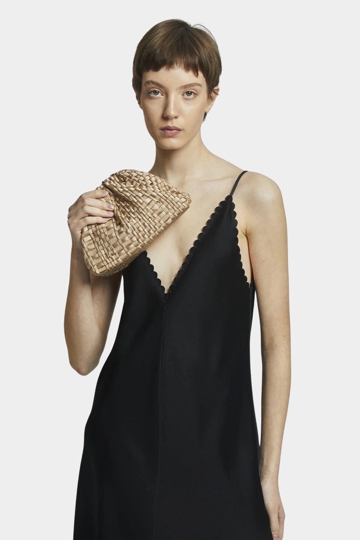 Model holding Maria La Rosa Mini Game Bag in Biscotto woven ribbon handbag