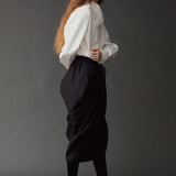 Side view of the Mijeong Park white cotton shirt styled with a sculptural black skirt
