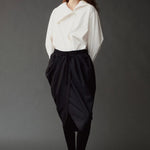 Front view of the Mijeong Park white cotton shirt styled with a draped black midi skirt