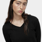 Portrait view of black cotton blend v neck knit top by Mijeong Park with lightweight knit texture
