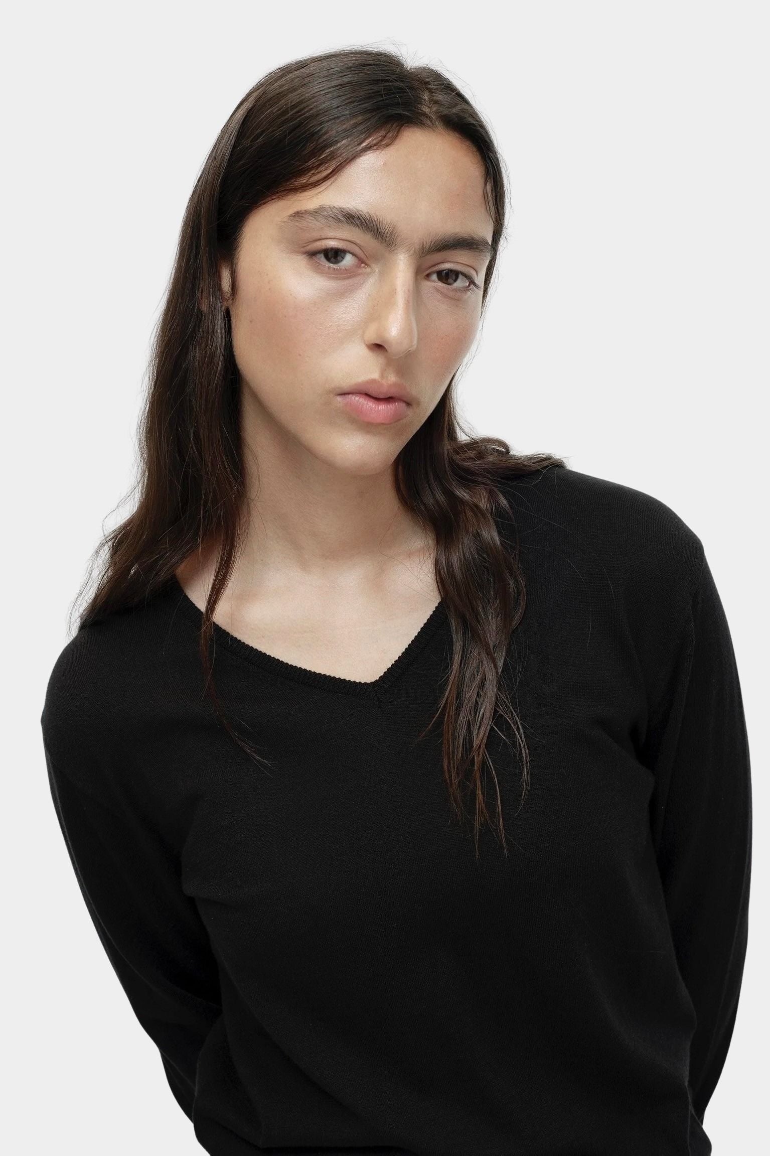 Portrait view of black cotton blend v neck knit top by Mijeong Park with lightweight knit texture